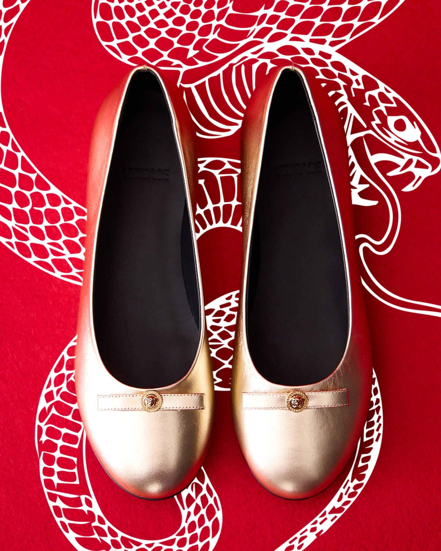 Versace Metallic leather ballerinas with bow. White snake motif on a red background.