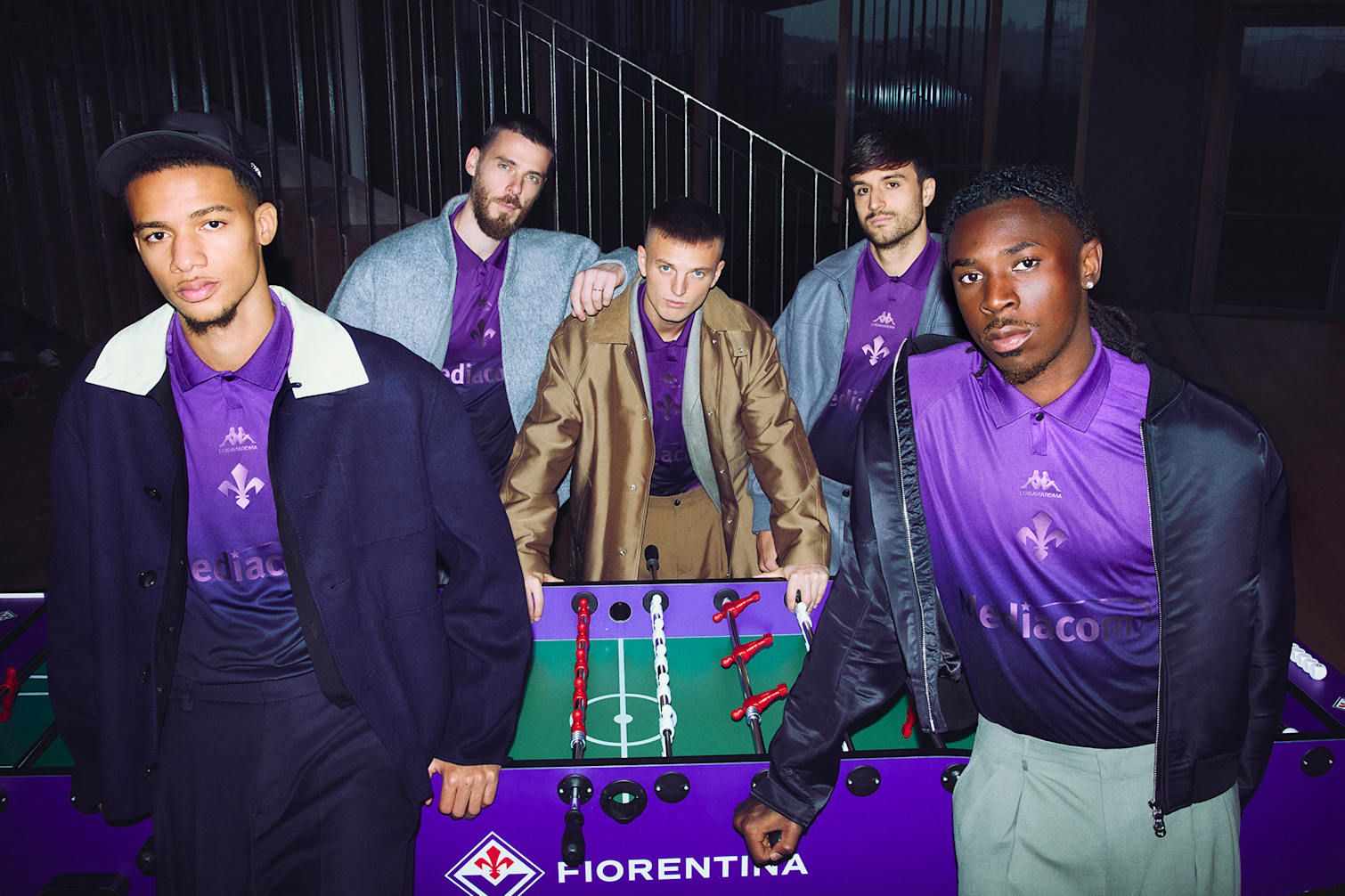 ACF Fiorentina players huddle around a foosball table