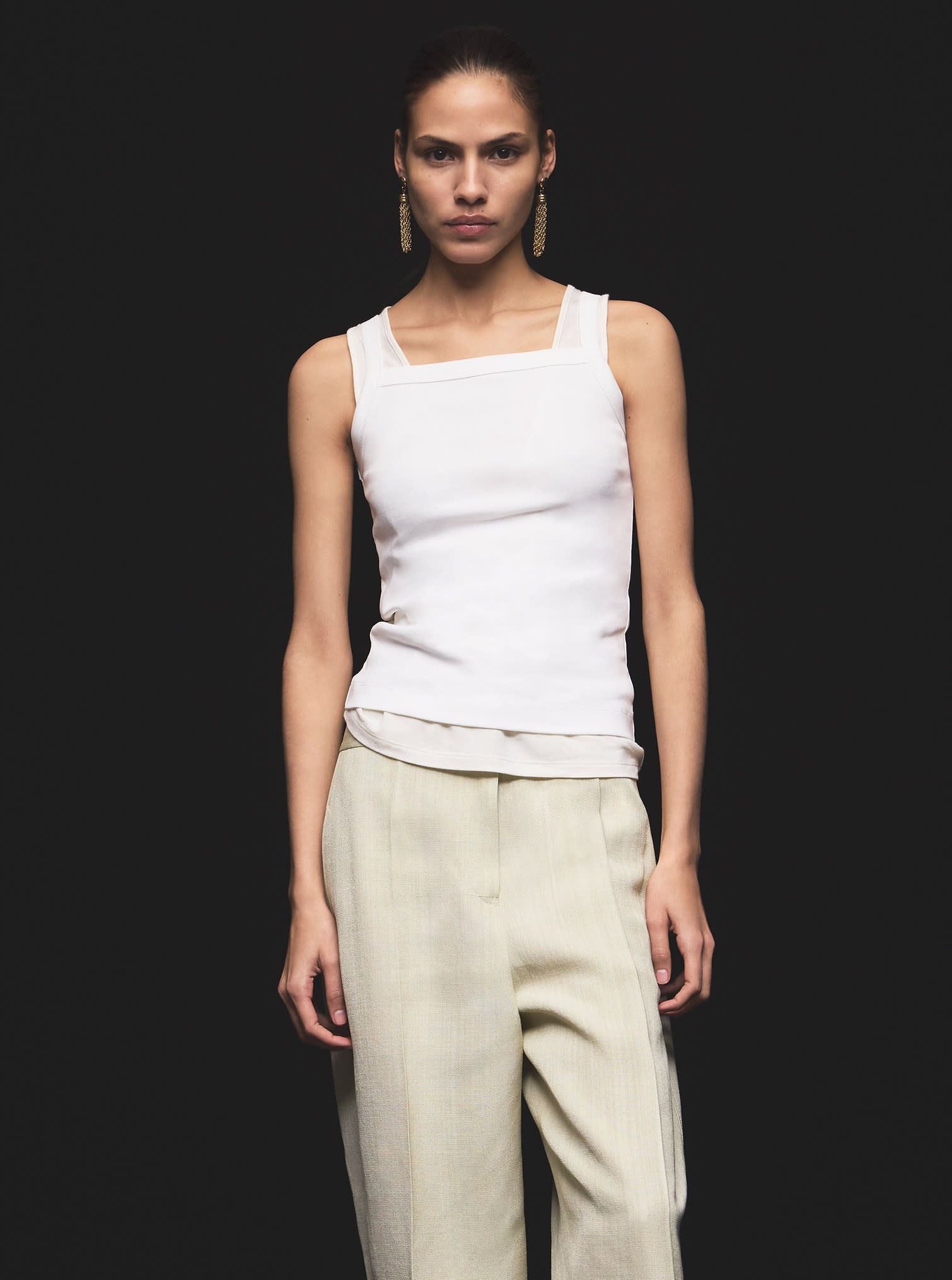 Women look with white cotton tank top and beige pants