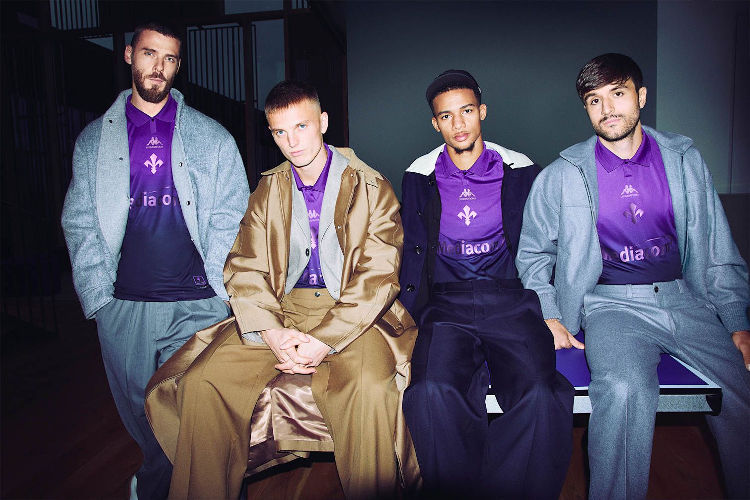 A group of soccer players wearing wool jackets over their new jerseys