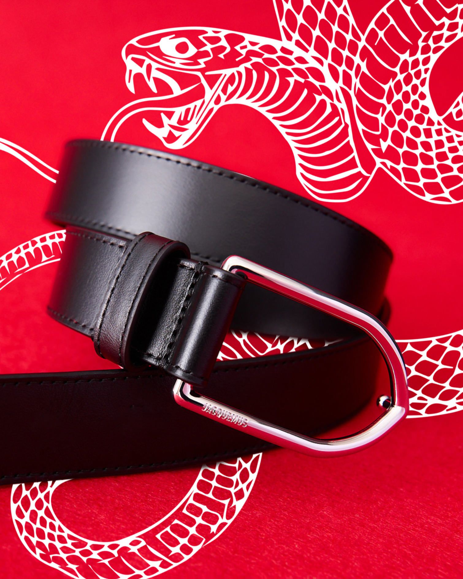 Jacquemus La Ceinture leather belt. White snake motif on a red background.